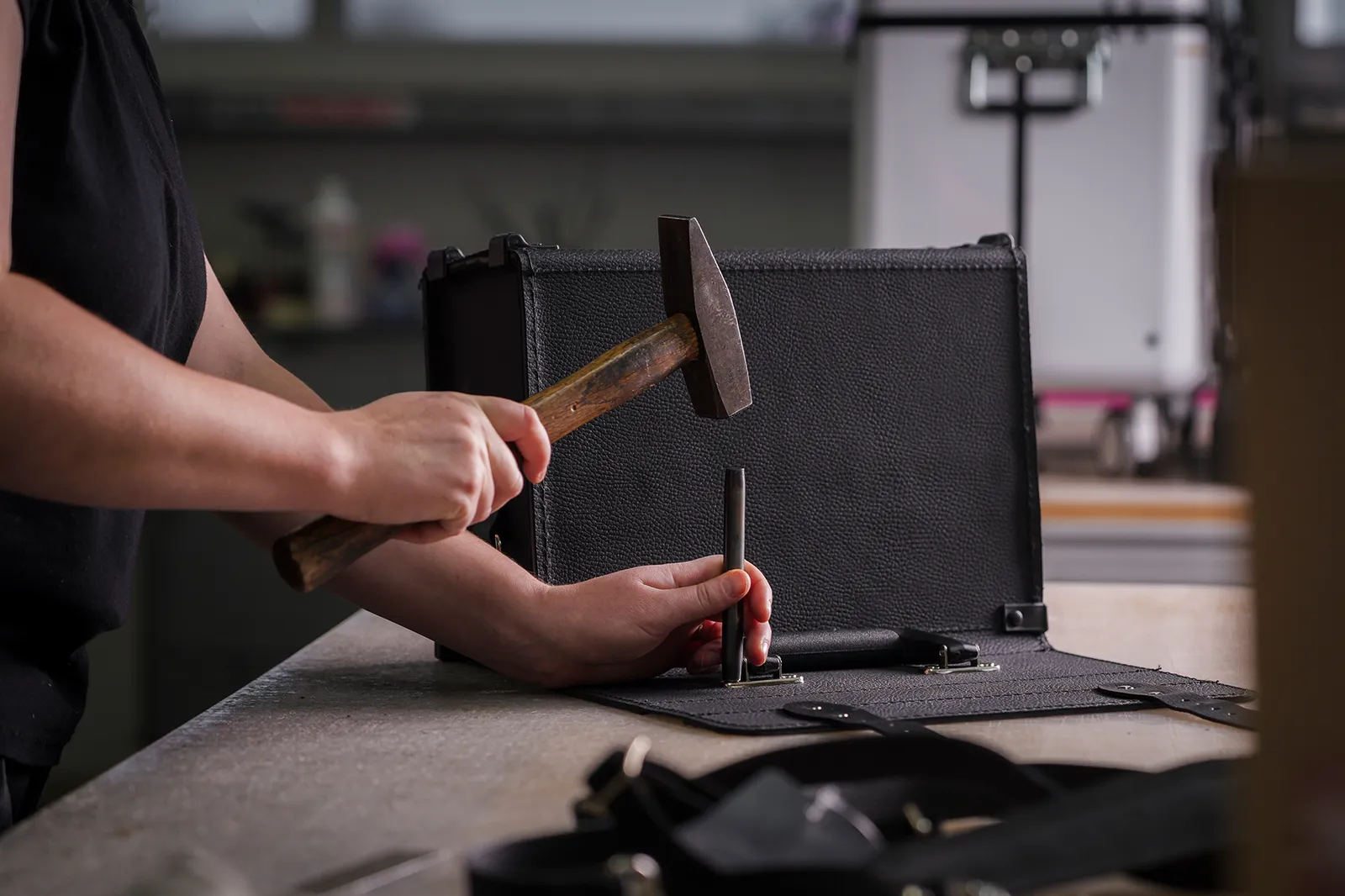 Employee rivets handle by hand in production